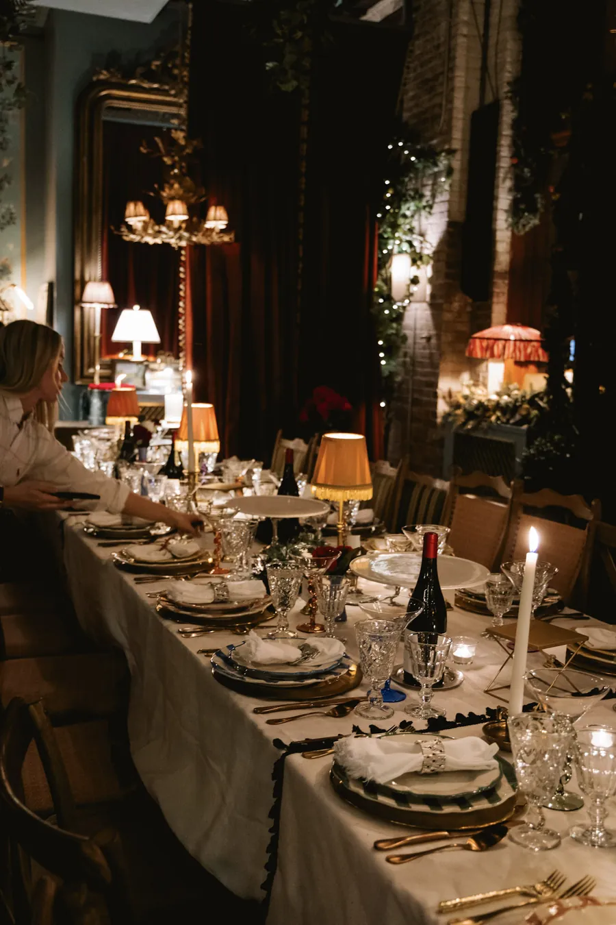 Guests at a long candlelit holiday dinner
