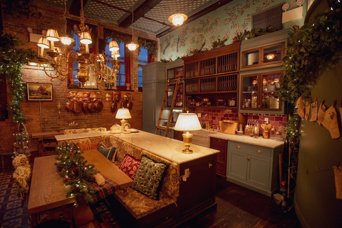 Kitchen and banquette table with copper pots, garland and lamplight