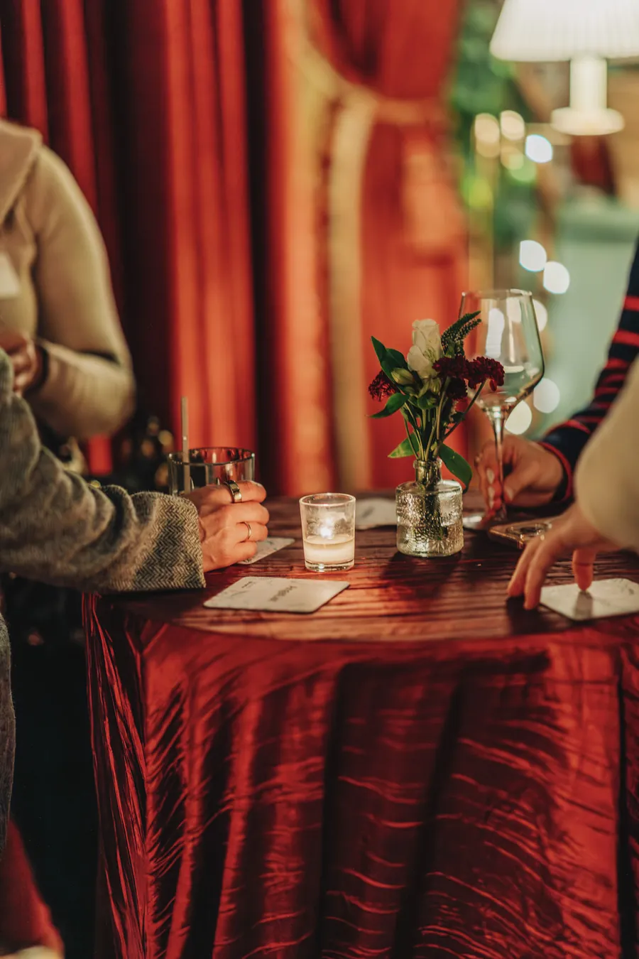 Guests with drinks at a red cocktail table