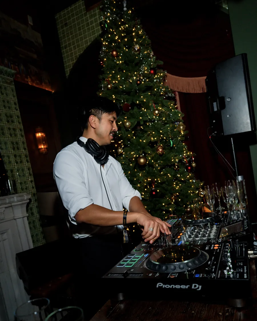 DJ playing in front of a lit tree