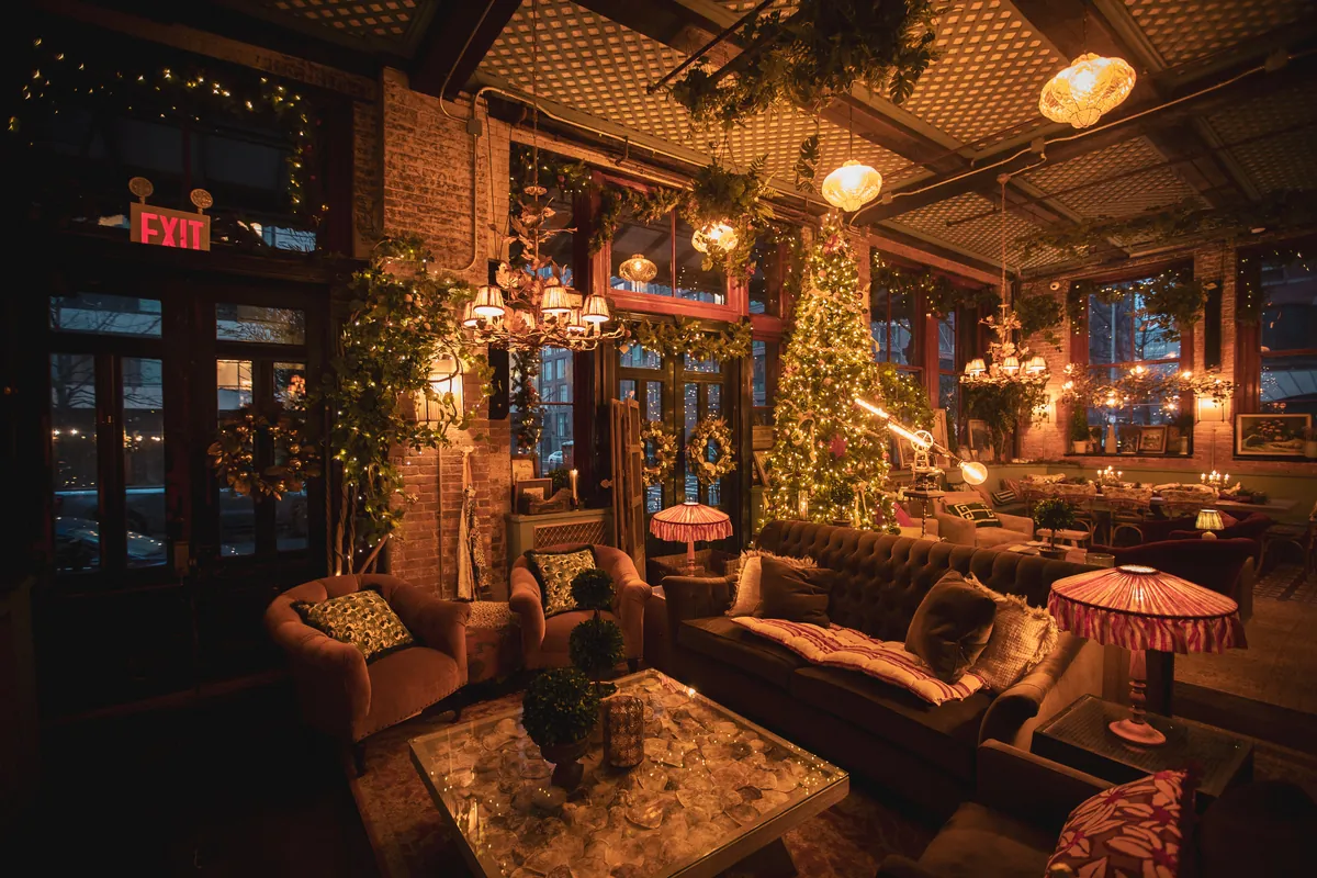 Lounge with velvet sofas and a lit tree, dressed for the holidays