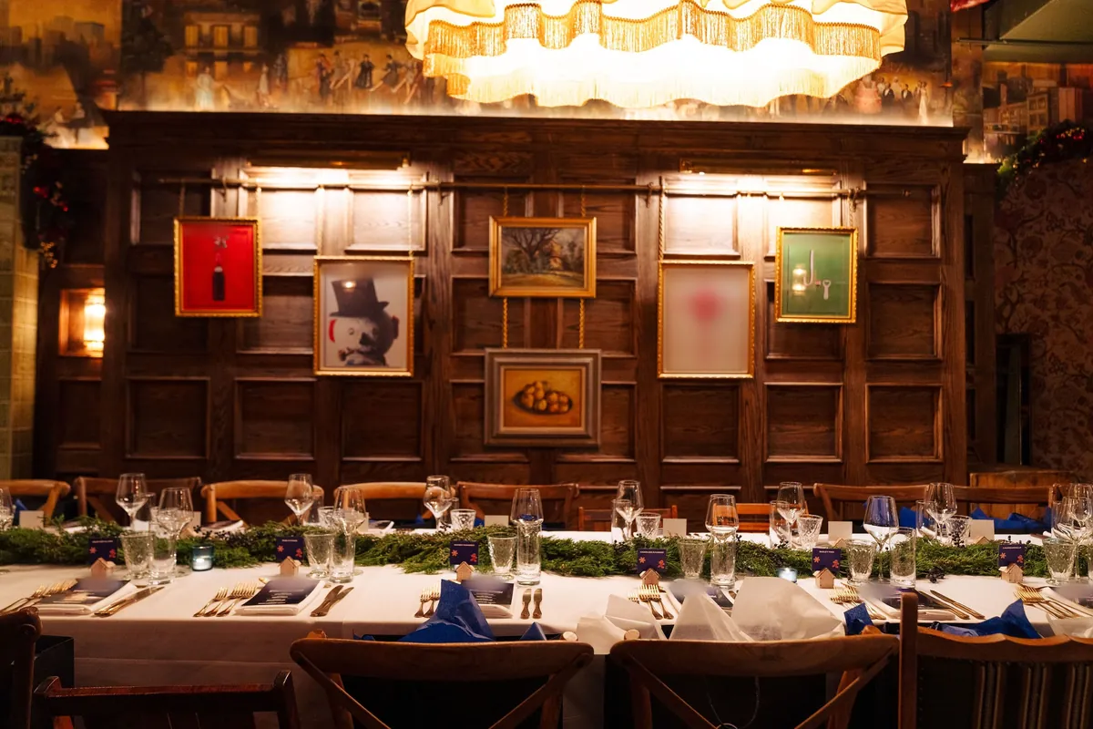 Long dinner table set beneath the chandelier