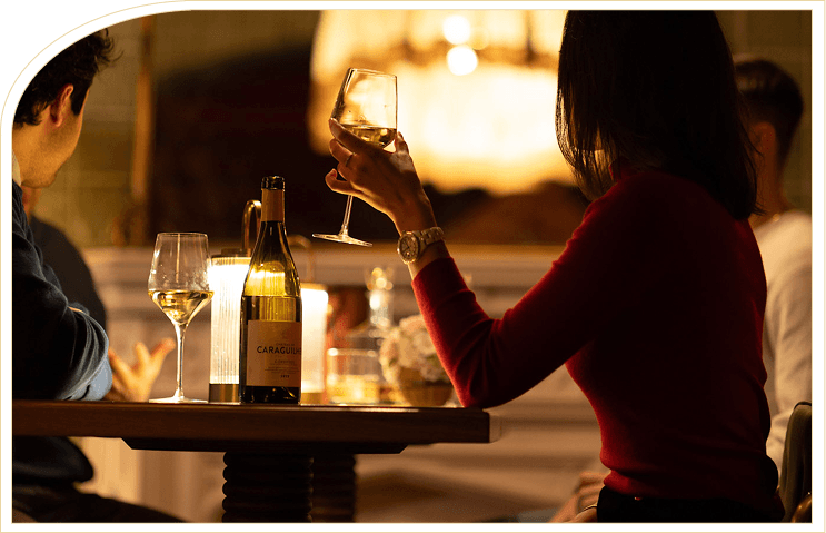 Members sharing wine at a Maxwell table